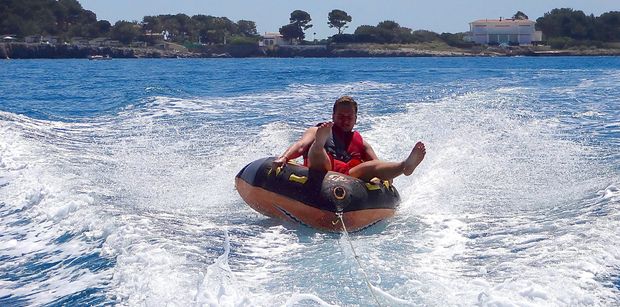 Enjoying being towed on an inflatable behind a tender.