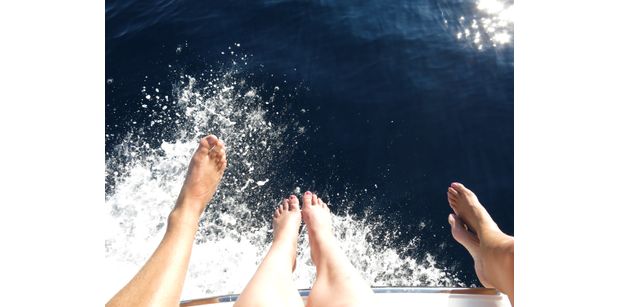 Sitting on the edge of the yacht's bow while cruising.