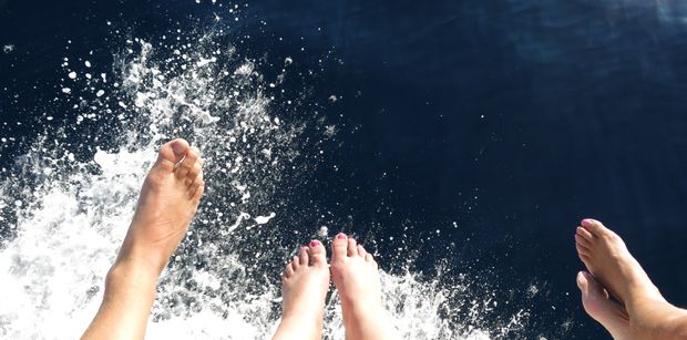 Sitting on the edge of the yacht's bow while cruising.