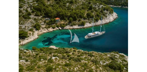 aerial shot of superyacht marallure gliding near coastline