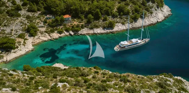 aerial shot of superyacht marallure gliding near coastline