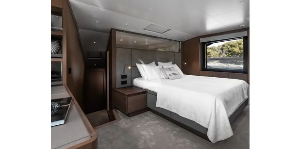 ZATARA II Sanlorenzo SL90A - full-beam master suite on the main deck of ZATARA II, featuring a large bed with white linens, dark wood paneling, and a large side window with sea views