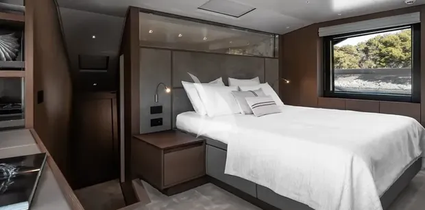 ZATARA II Sanlorenzo SL90A - full-beam master suite on the main deck of ZATARA II, featuring a large bed with white linens, dark wood paneling, and a large side window with sea views
