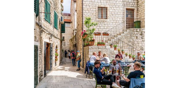 old town alleyway in split croatia with restaurants and ancient looking buildings