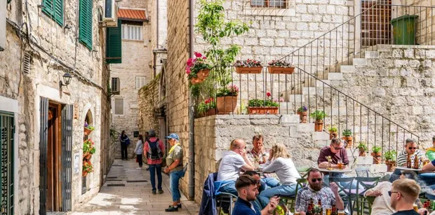old town alleyway in split croatia with restaurants and ancient looking buildings