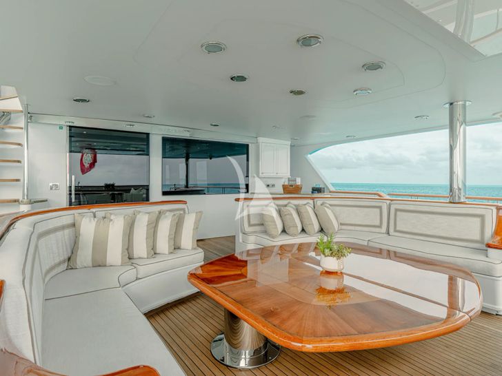 FAR FROM IT Richmond 142 - main aft deck lounge with a wooden center table topped with glass FAR FROM IT Richmond 142 - main aft deck lounge with a wooden center table topped with glass