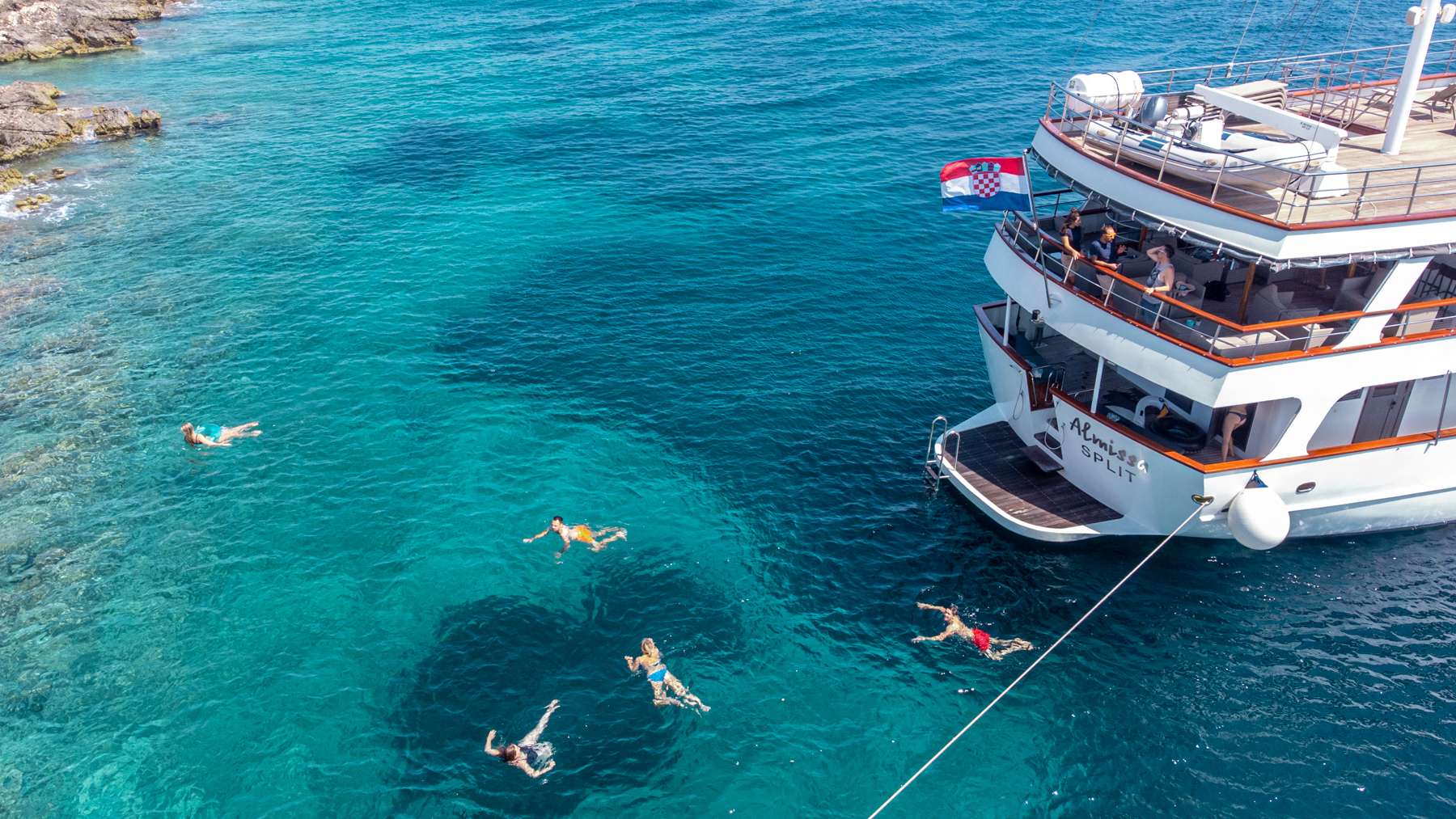 ALMISSA Custom Motor Yacht 40m - guests swimming in turquoise Adriatic water