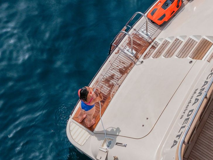 ACCAMA DELTA Azimut 30m - guest enjoying a freshwater shower on swim platform ACCAMA DELTA Azimut 30m - guest enjoying a freshwater shower on swim platform