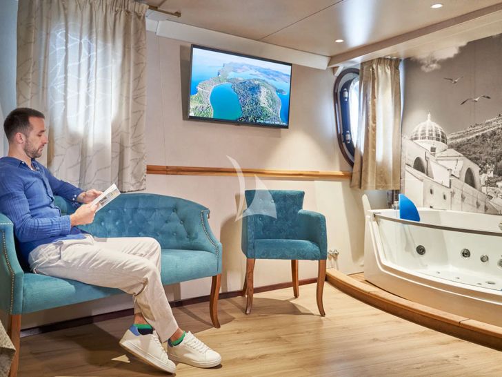 CASABLANCA Custom Yacht 61m - guest seated on the master cabin couch CASABLANCA Custom Yacht 61m - guest seated on the master cabin couch