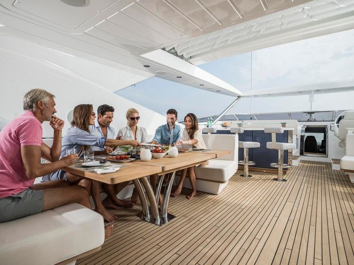 FLEUR Sunseeker 116 - guests on the flybridge dining area FLEUR Sunseeker 116 - guests on the flybridge dining area