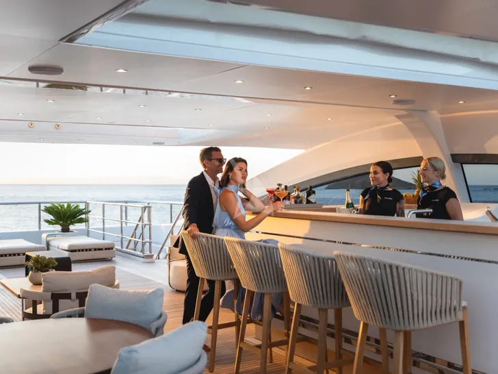 MINE GAMES Benetti B.Now 50 - guests drinking cocktails in the sun deck bar MINE GAMES Benetti B.Now 50 - guests drinking cocktails in the sun deck bar