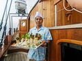 MUTIARA LAUT Phinisi 47m - steward ready to serve food MUTIARA LAUT Phinisi 47m - steward ready to serve food