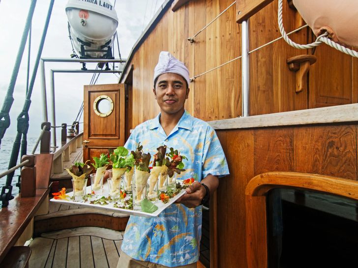 MUTIARA LAUT Phinisi 47m - steward ready to serve food MUTIARA LAUT Phinisi 47m - steward ready to serve food