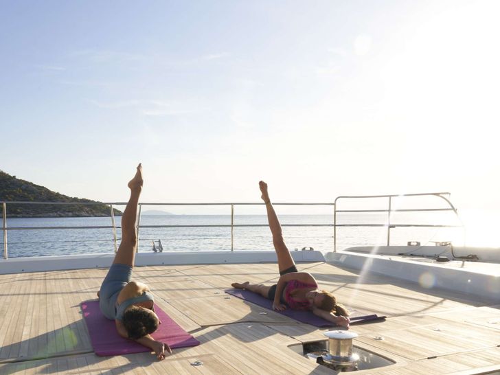 CRAZY HORSE Lagoon 78 - guests having a yoga session onboard CRAZY HORSE Lagoon 78 - guests having a yoga session onboard