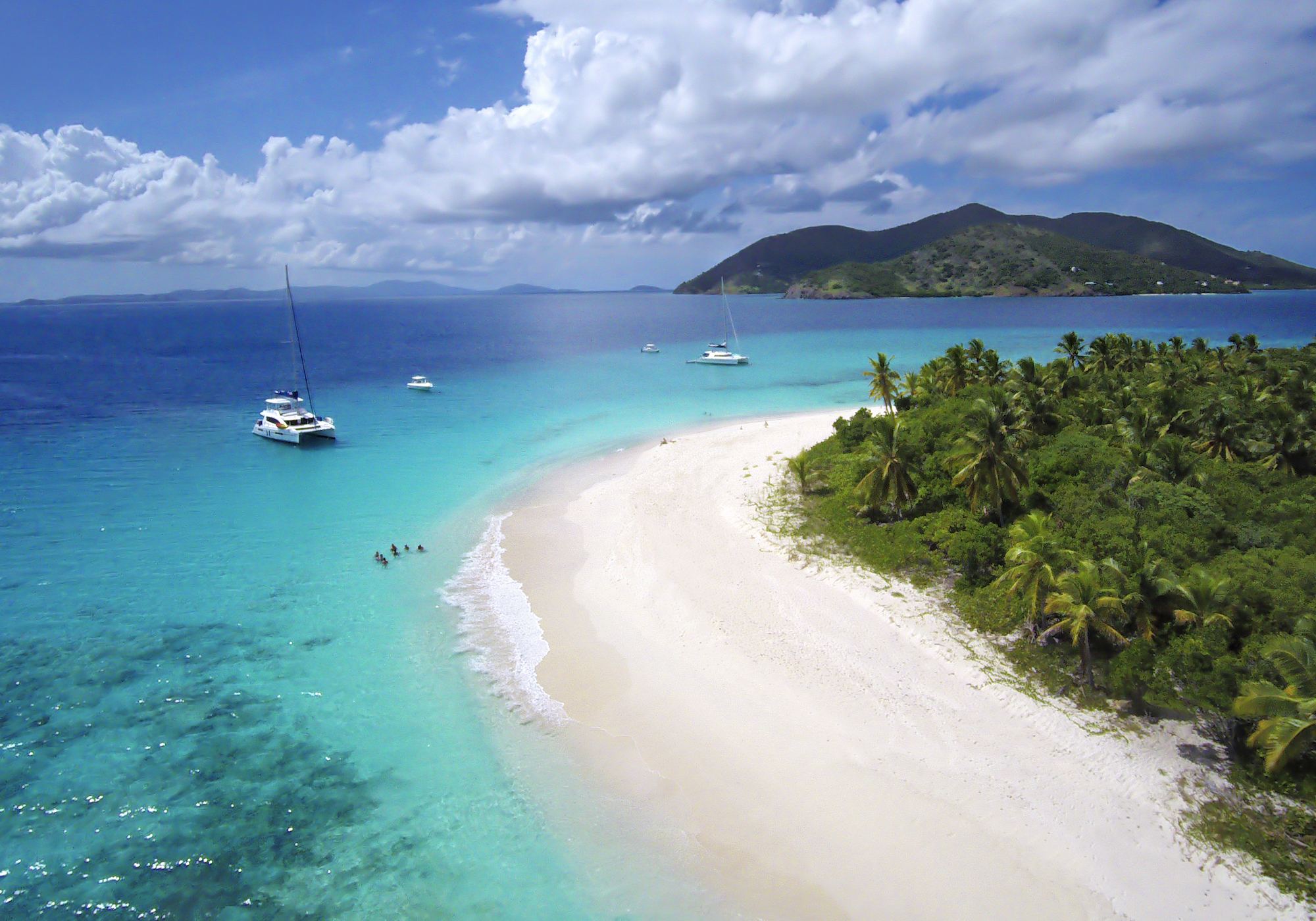 Crewed Catamaran Anchored off Tropical Island in BVI