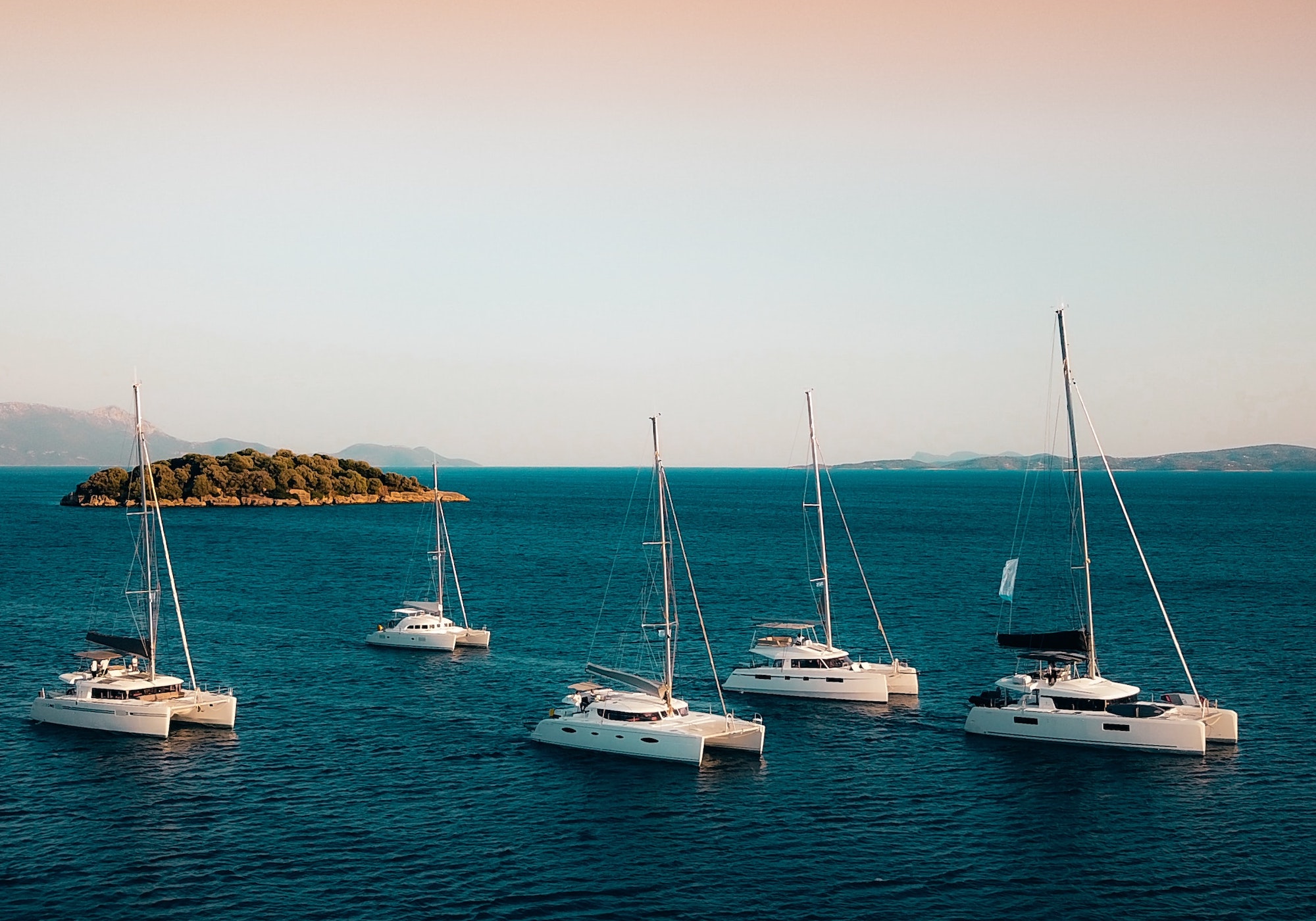 Fleet of Crewed Catamarans at Sunset in Greece