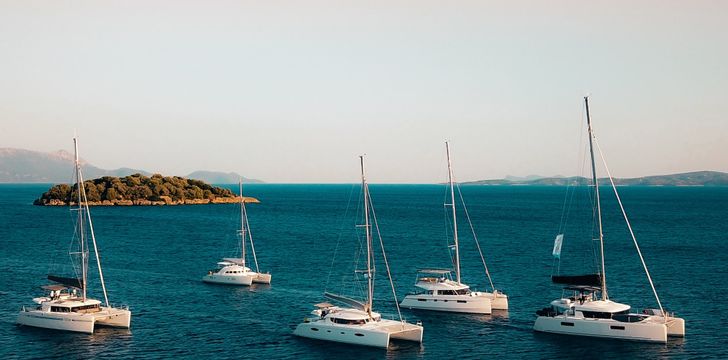 Fleet of Crewed Catamarans at Sunset in Greece