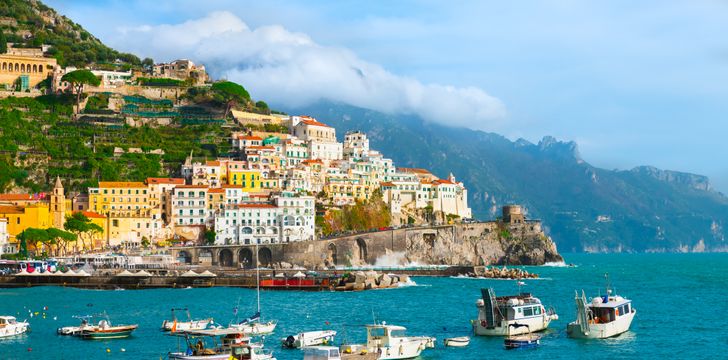 aerial shot of the amalfi town in the amalfi coast with yachts anchored near its port