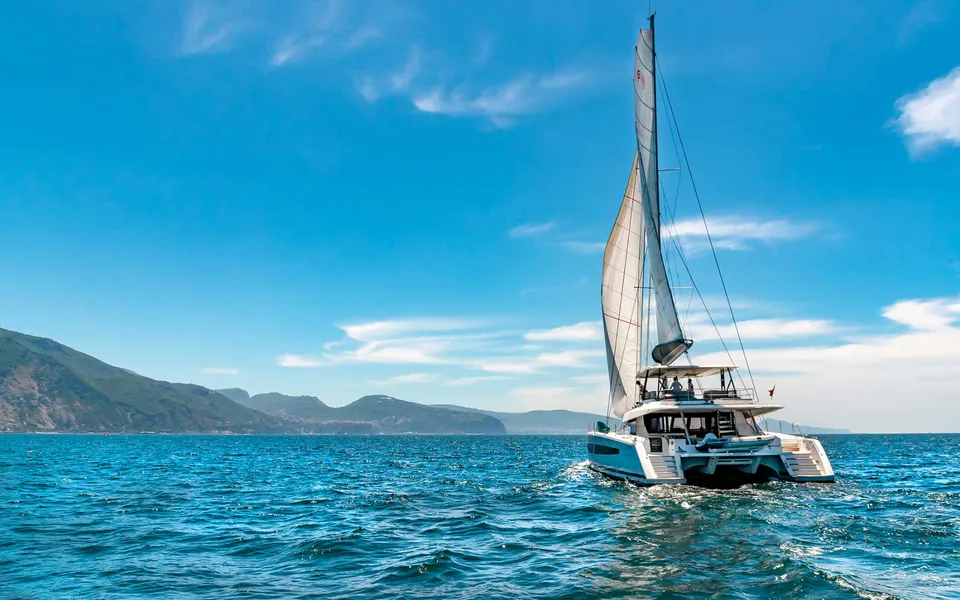 luxury crewed catamaran liberta cruising across the blue amalfi coast water