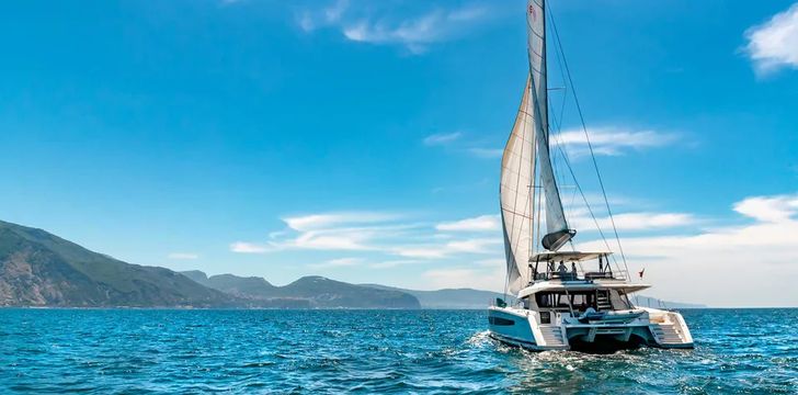 luxury crewed catamaran liberta cruising across the blue amalfi coast water