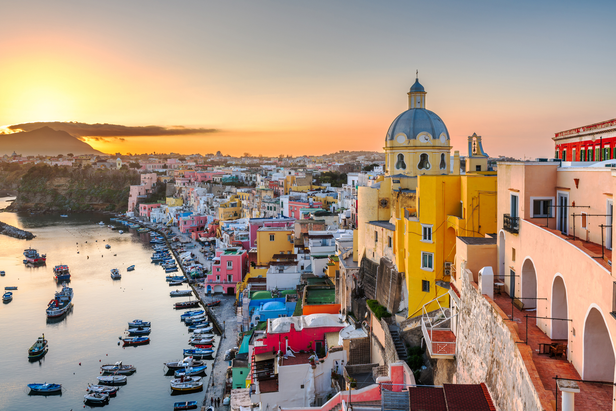 the amazing sunset horizon of procida with its colorful pastel town