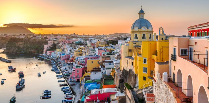the amazing sunset horizon of procida with its colorful pastel town