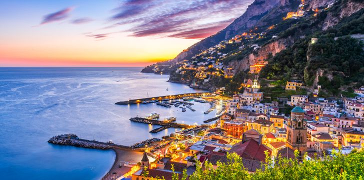 beautiful sunset view of the amalfi coast with yachts lined in its iconic ports